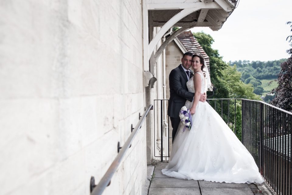 The happy couple positioned on the balcony of the registry office with a beautiful view.