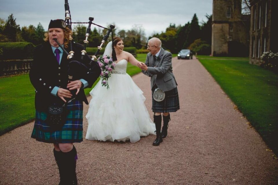The bride and her father on the way to the ceremony in pursuit of a bagpiper!