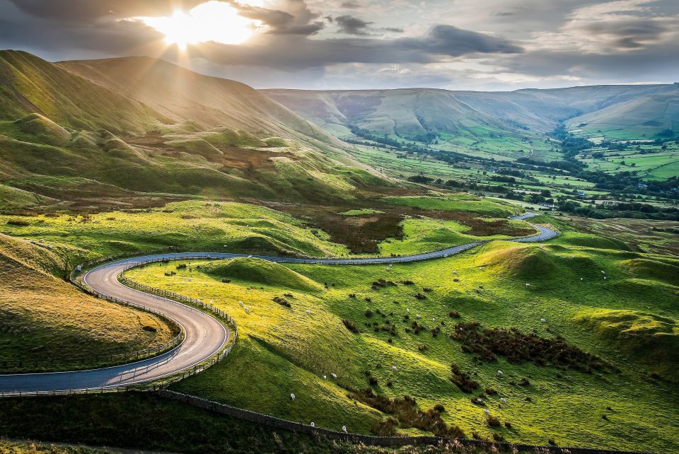Sunset at Mam Tor, Peak District National Park, with a view along the winding road down to Hope Valey, in Derbyshire, England.
