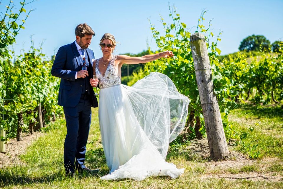 The bride and groom posing in the vineyard.