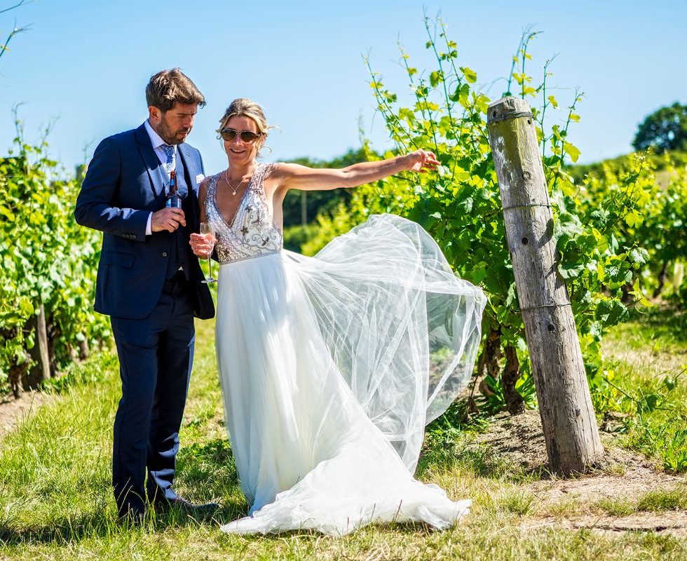 The bride and groom posing in the vineyard.