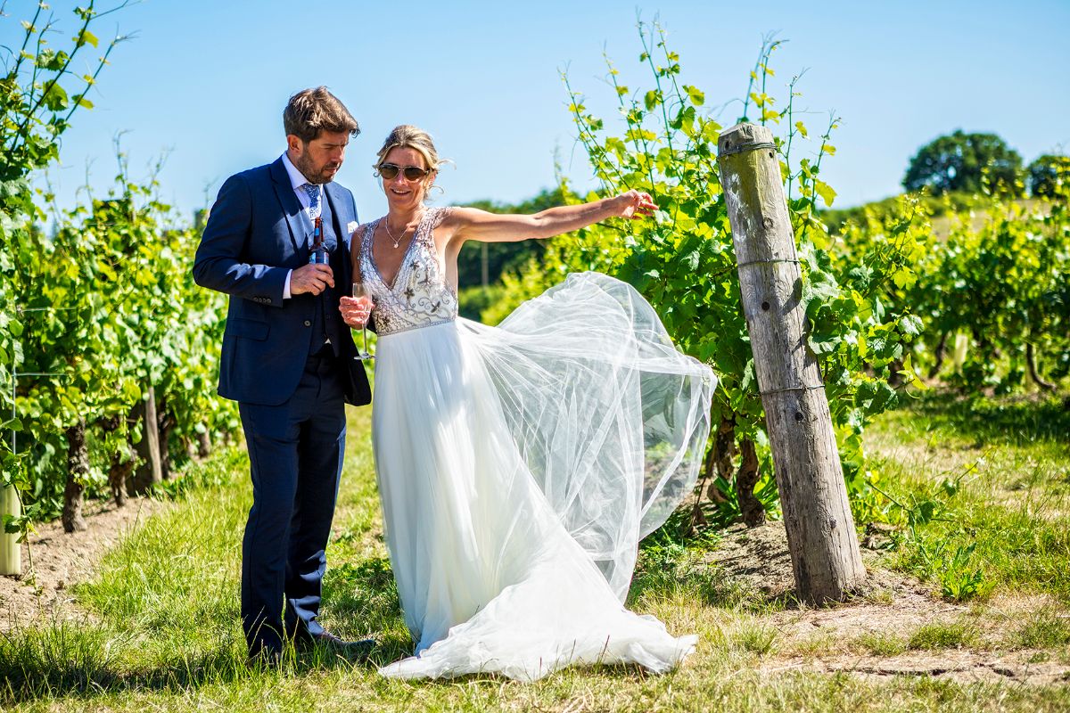 The bride and groom posing in the vineyard.